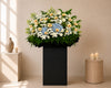 Blue Dawn Farewell Condolences Flower Stand with blue hydrangea and white papermums, close-up of blooms