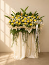 Solace Condolences Flower Stand with yellow paper mums, ping pongs and bird of paradise, front view