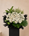 Iris Condolences Flower Stand with white gerberas, ping pongs and pom poms, full arrangement