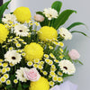 Warm Goodbye Condolences Flower Stand display detail view showing white gerberas and yellow papermums arrangement