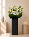 Blue Dawn Farewell Condolences Flower Stand with blue hydrangea and white papermums, front view