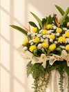 Solace Condolences Flower Stand with yellow paper mums, ping pongs and bird of paradise, full arrangement